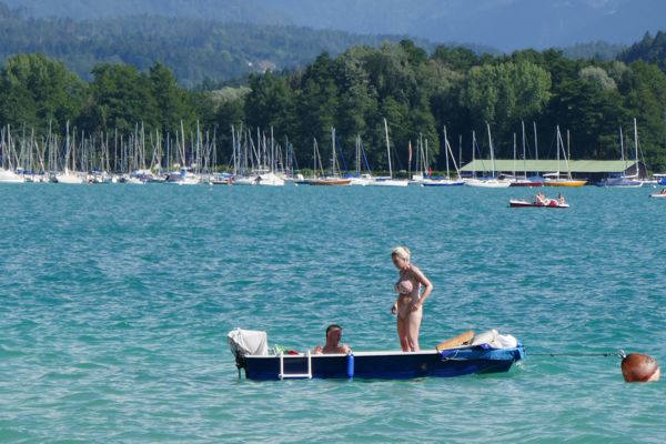 Das Paar im blau-weißen Boot mit Außenbordmotor auf dem Wörthersee