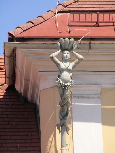 Die linke Meerjungfrau am gelb-weißen Haus am St. Veiter Ring