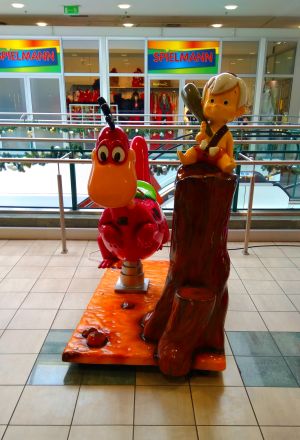 Dinosaurier und Steinzeitbub mit Keule